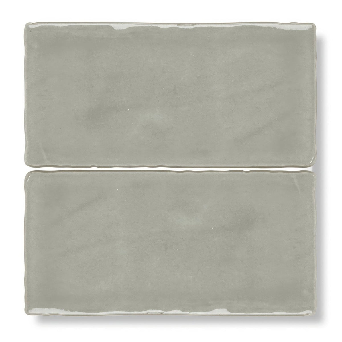 Two matte-finished gray ceramic carnival sella grey glazed rectangular tiles with slightly uneven edges