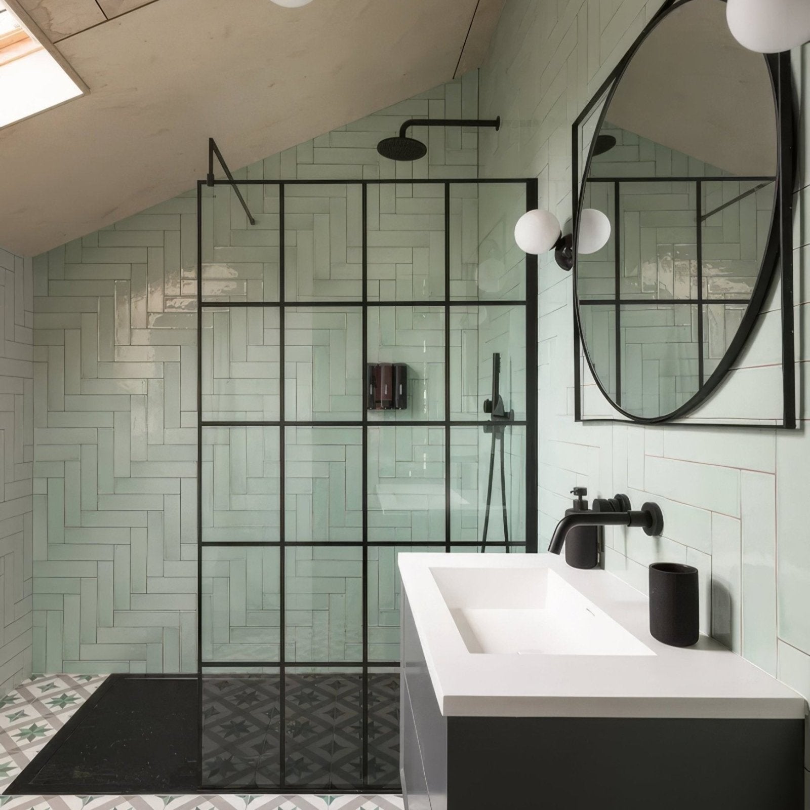 Modern black-framed glass shower enclosure featuring a herringbone pattern of light green Carter ceramic mint tiles