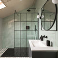 Modern black-framed glass shower enclosure featuring a herringbone pattern of light green Carter ceramic mint tiles