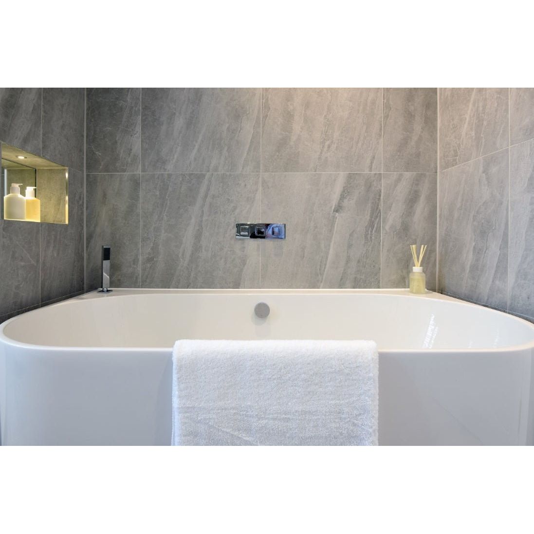 Cashmire Oyster 60 x 60cm stone-effect tiles with a freestanding bathtub and draped towel