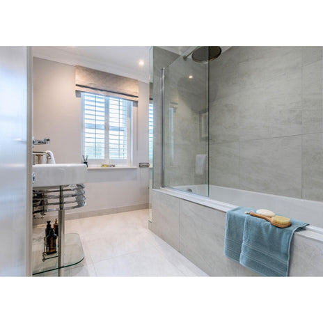 Cashmire White 60 x 60cm cream marble-effect tiles with a light blue towel over a bathtub