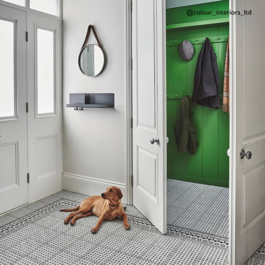 A golden brown labrador retriever lying on casino baccarat patterned tile showcasing decorative floor design
