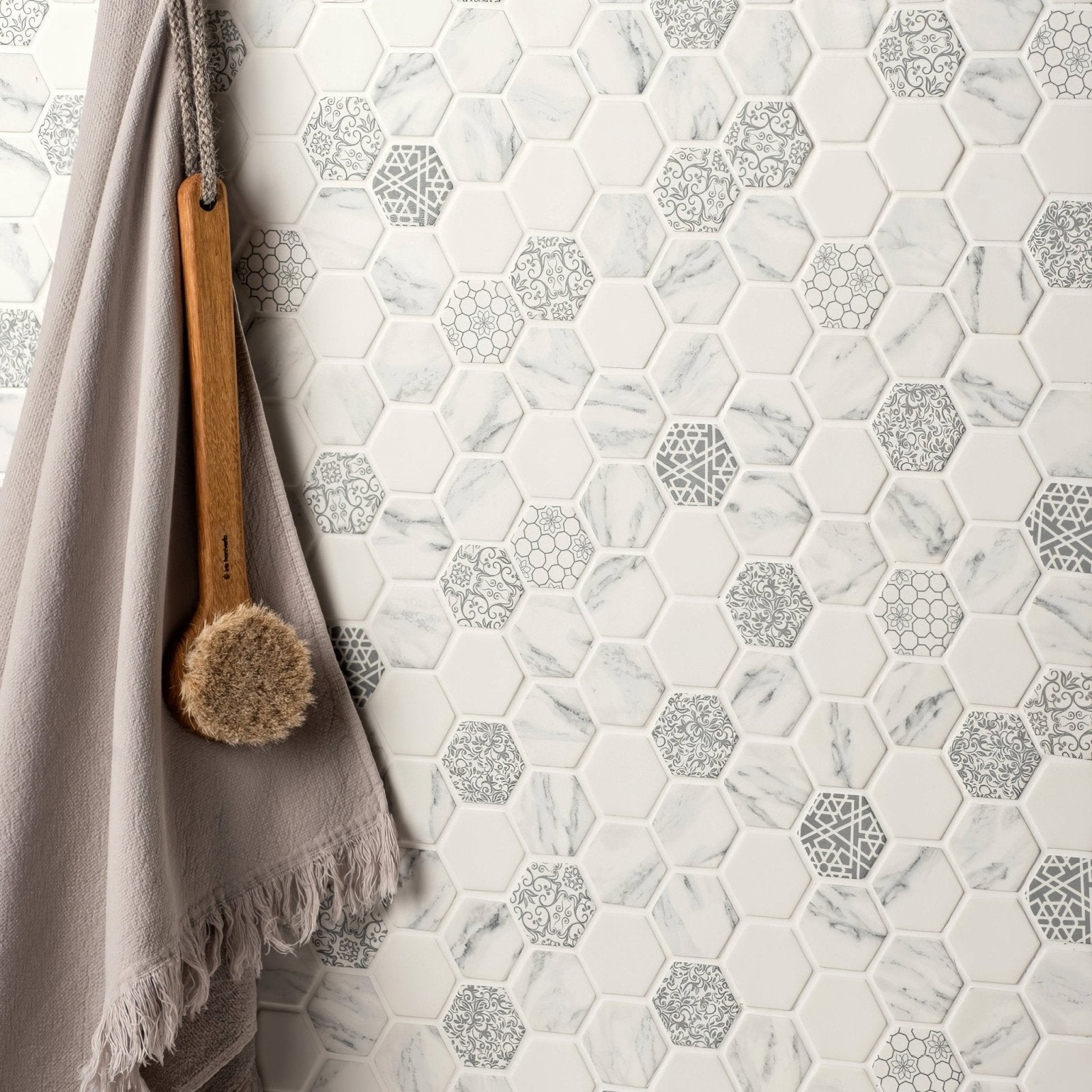 White and gray hexagonal caspar recycled glass mosaic tile wall with marble-patterned and silver geometric accents