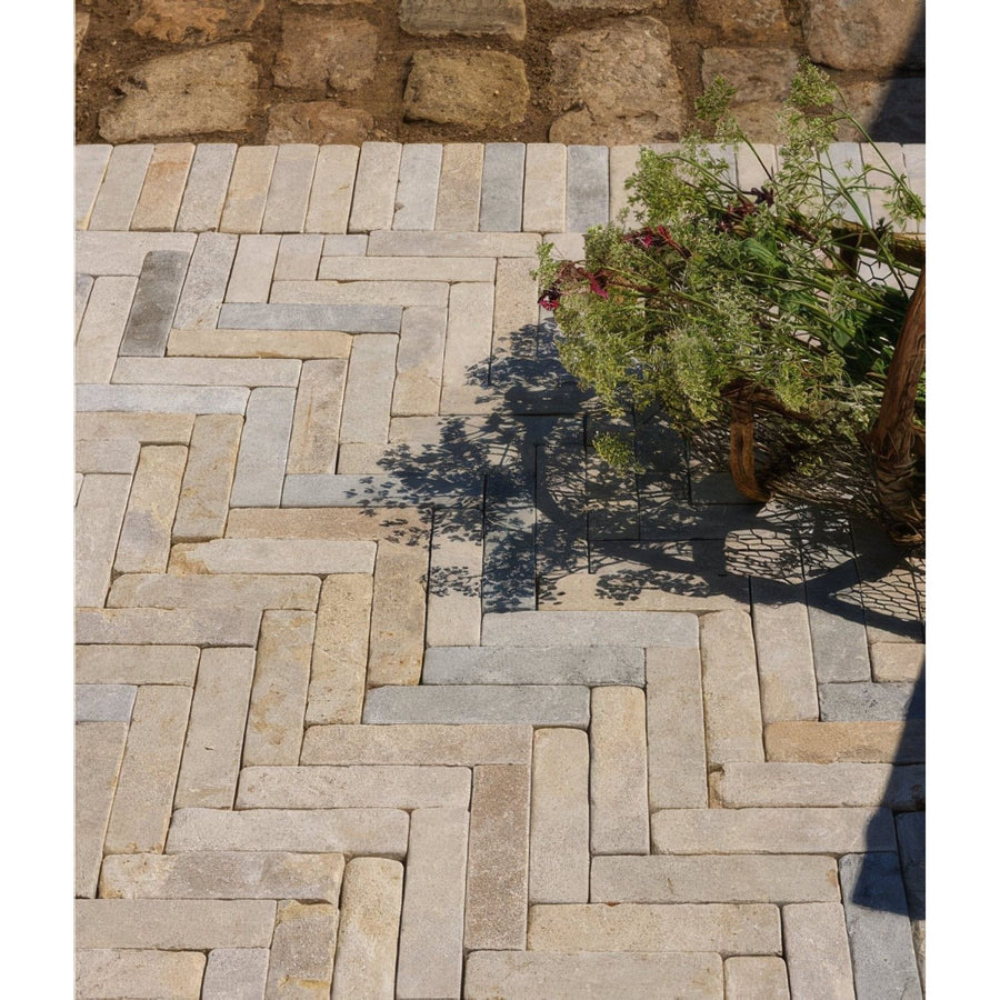 Castilan limestone tumbled klinkers stone pavers in natural beige and gray tones with herringbone pattern