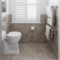 White ceramic toilet with matching lid against beige ceppo mix 60 x 60cm marble-patterned tiles