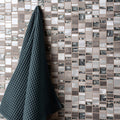 Ceres Rectangle Mix Mosaic grey and black glass mosaic wall with a dark teal waffle towel