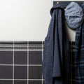 Boot room wall tiled in Charcoal Grey with an Omega bead moulding course and cornice, a navy coat and cap hanging above