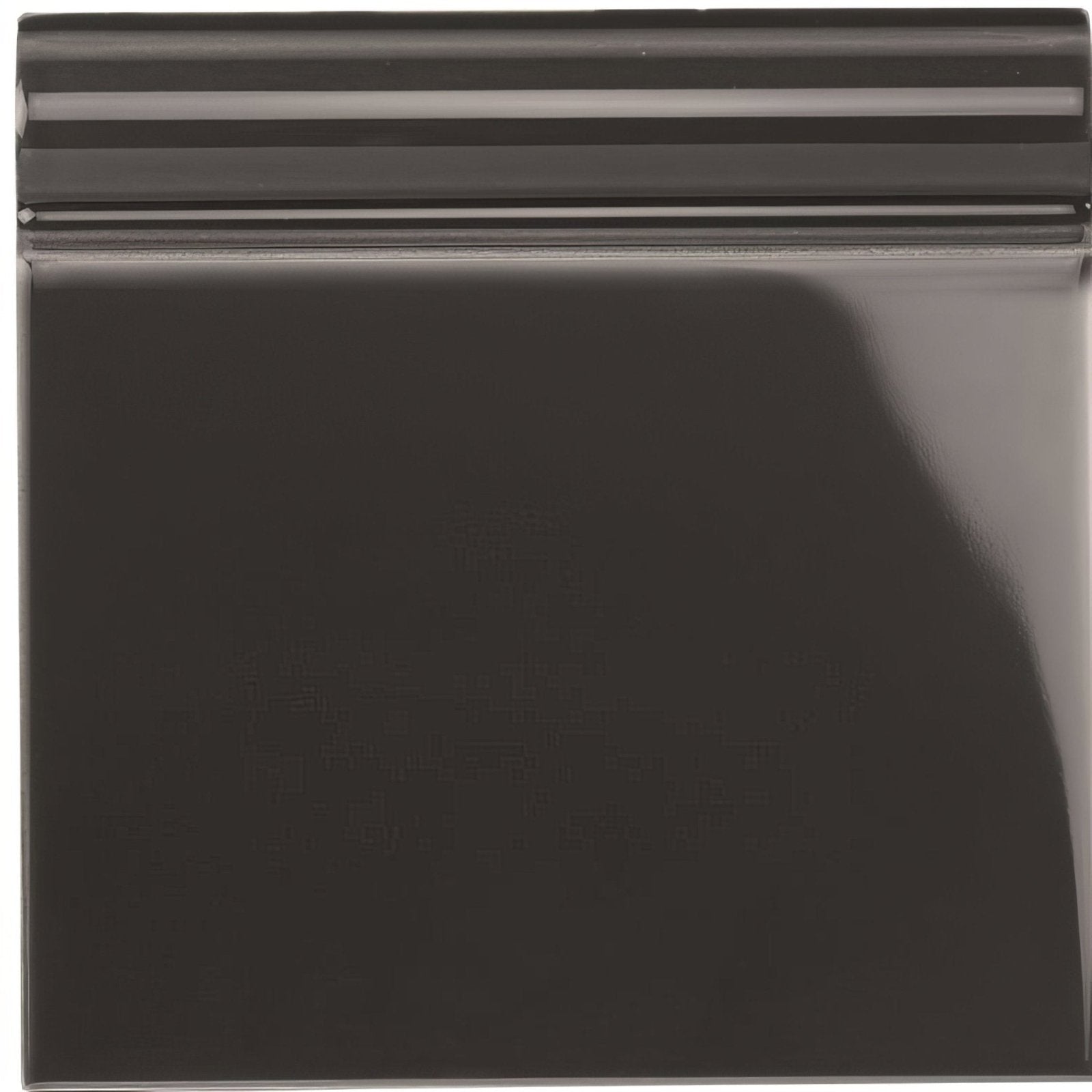 Charcoal grey skirting tile with black glossy ceramic surface and subtle horizontal ridges along the top edge