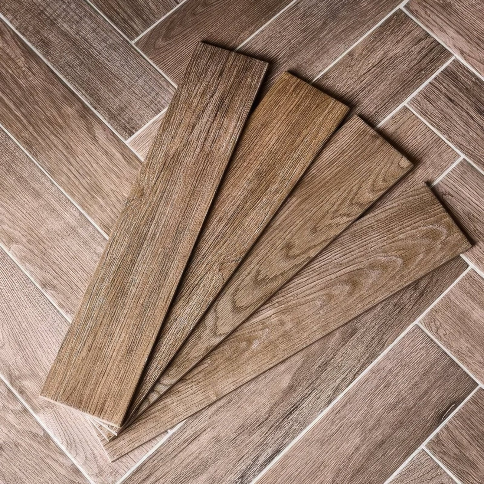 Brown wood-grain vinyl floor tiles in chatham porcelain walnut arranged in a herringbone pattern