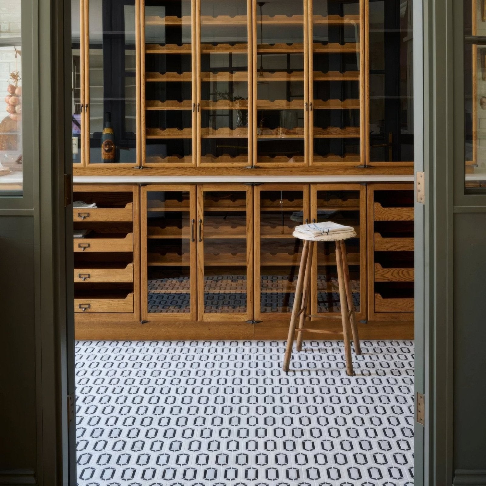 Chequers Court Double Hexagon white and black hexagon mosaic flooring with a wooden upholstered stool