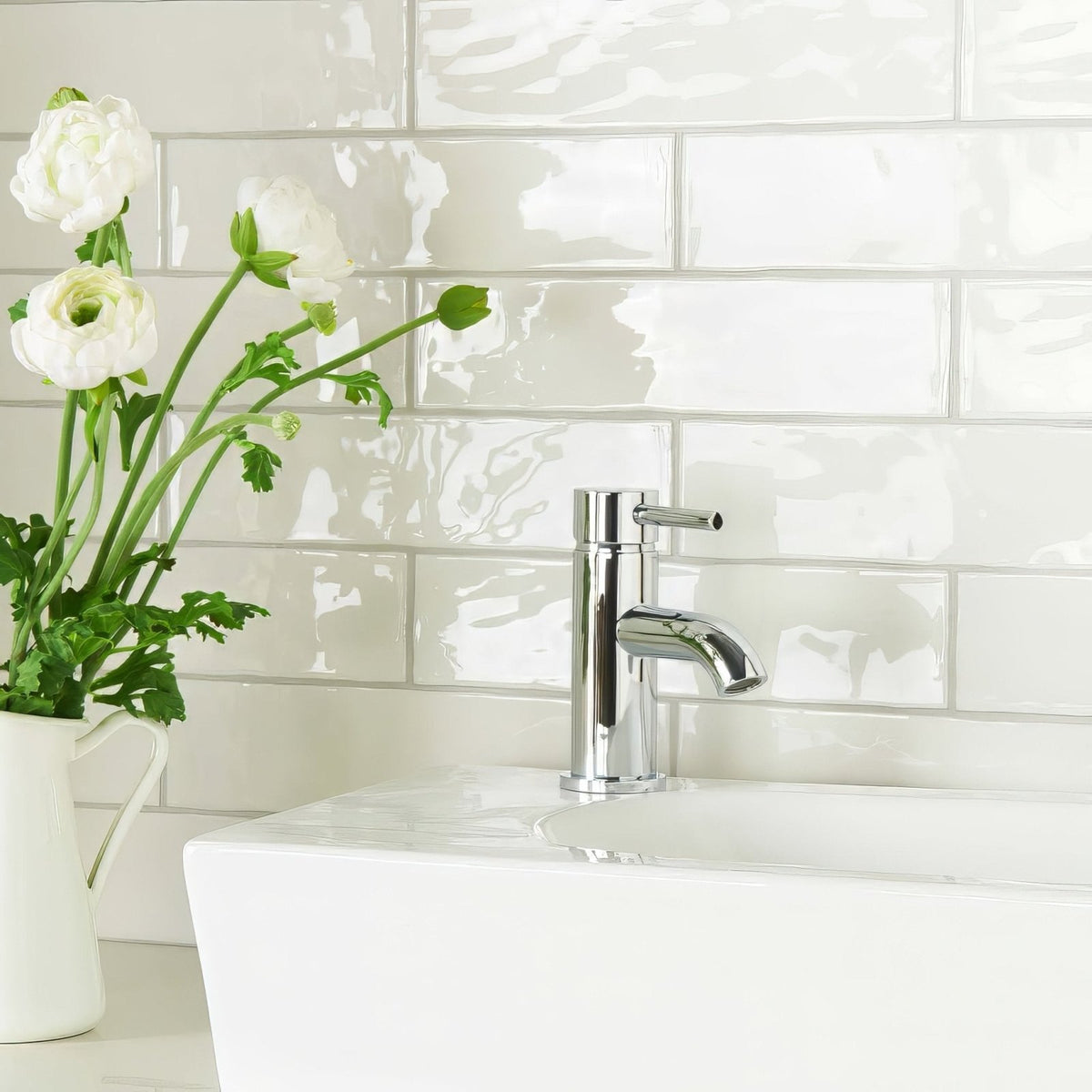 Chrome-finished single-handle bathroom faucet with sleek modern design featured with china white large brick tile background