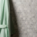 Cirrus Small Stone Hexagon grey marble hexagon mosaic wall with a light green waffle bathrobe