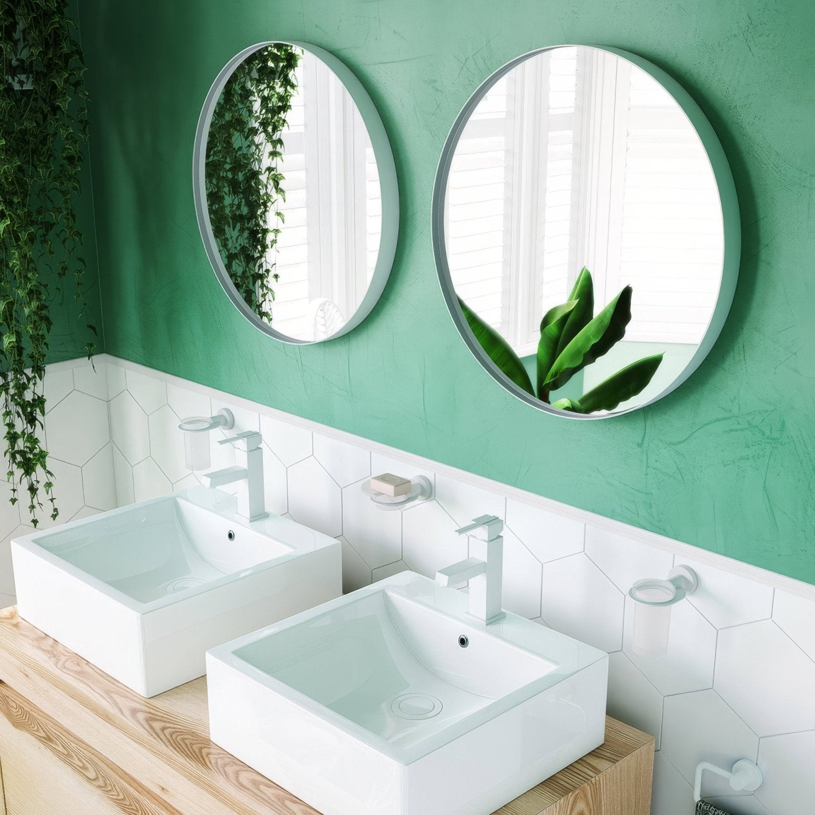 Two city round mirrors with sleek silver frames mounted on a green wall for modern home decor
