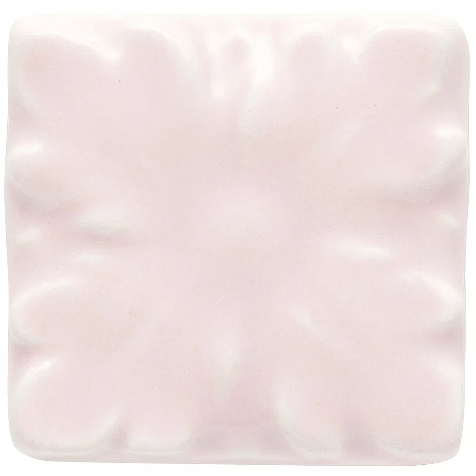 A soft pink ceramic tile clare knightsbridge with a subtle raised floral pattern for decorative use