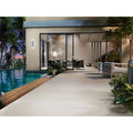 Modern minimalist outdoor patio featuring cleveland 1833 bone matt tiles with sleek glass doors and an infinity pool