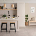 Minimalist white kitchen island with smooth countertop and integrated sink featuring cliff brick tile and black wooden stools