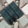 Teal ceramic subway tile with glossy gradient finish and black grout lines from copenhagen kit kat dark green mosaic