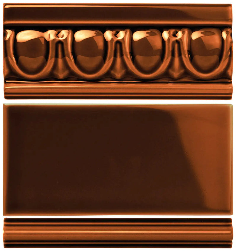 Copper-colored ceramic tile with a glossy finish and ornate, repeating scrollwork design.