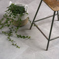 A cotehele opus porcelain grey natural woven basket with handles holding a trailing green ivy plant
