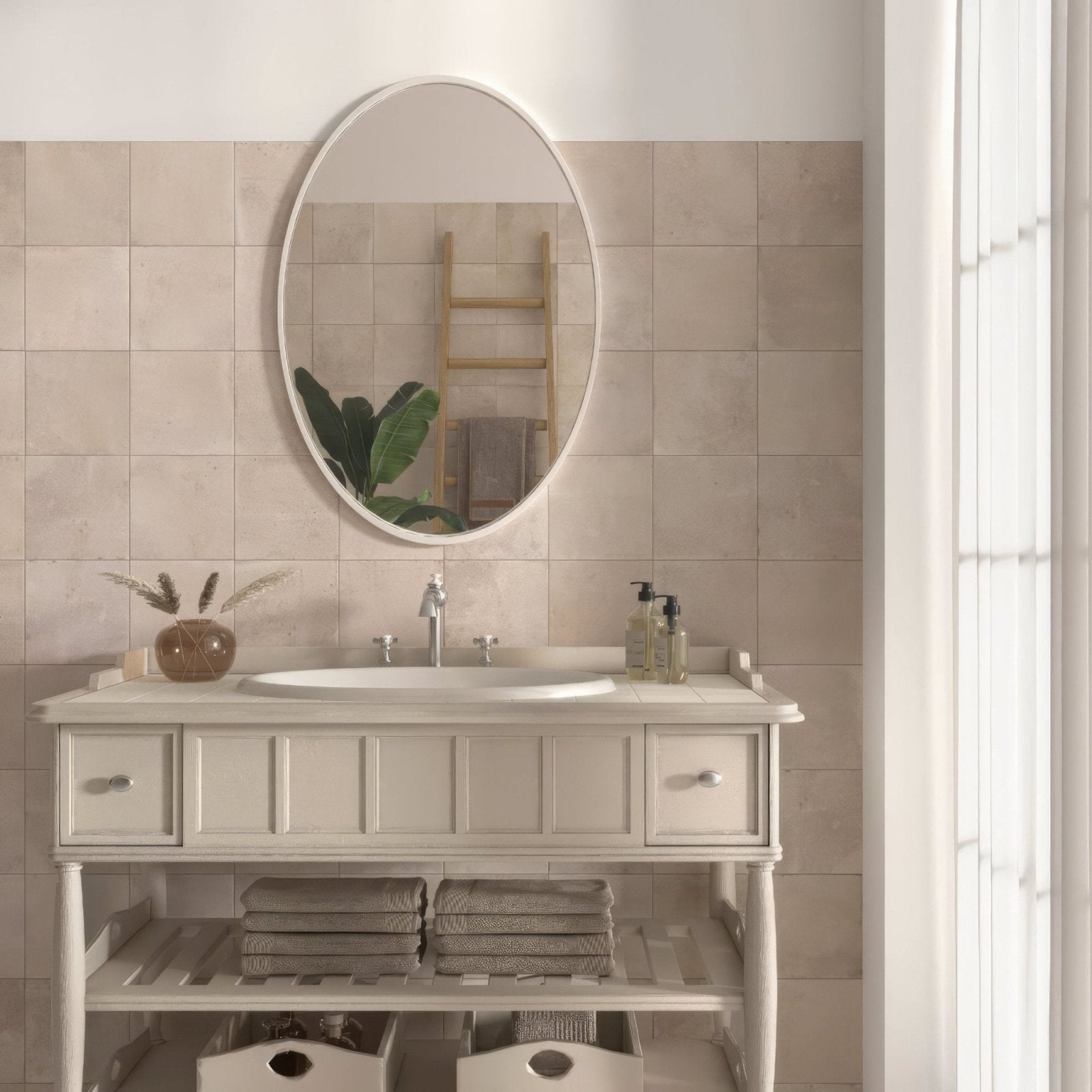 Oval-shaped mirror with sleek white frame mounted above sink featuring cotto blanc terracotta effect tiles background
