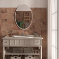 Oval-shaped mirror with white frame mounted above sink featuring cotto cuero terracotta effect tiles background