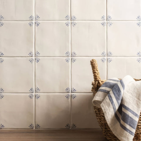 Cream-colored ceramic tiles with subtle gray floral motifs from country delft ada collection