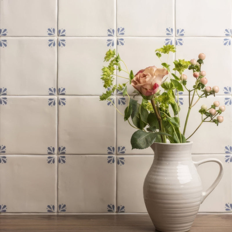 Cream-colored ceramic pitcher with ribbed texture and handle holding pink roses and greenery in country delft cornelia style