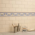 Cream-colored subway tile wall with decorative blue and yellow patterned border tile in county white albert moulding