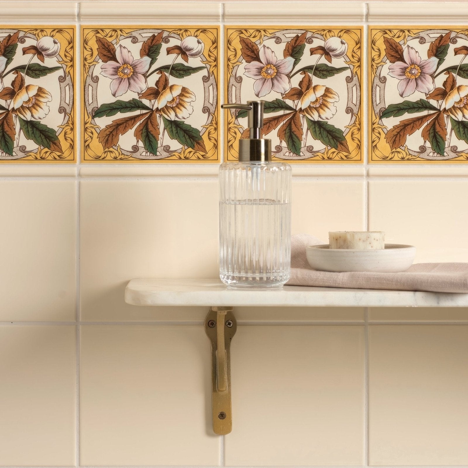Clear glass soap dispenser with metallic pump featured in county white albert moulding bathroom collection