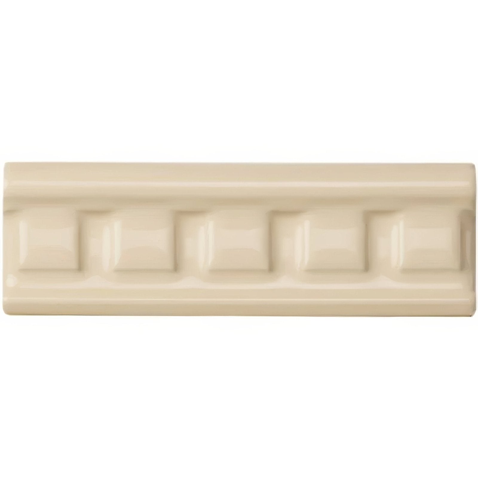 Cream-colored ceramic tile county white dentil moulding with a raised rectangular pattern along its length
