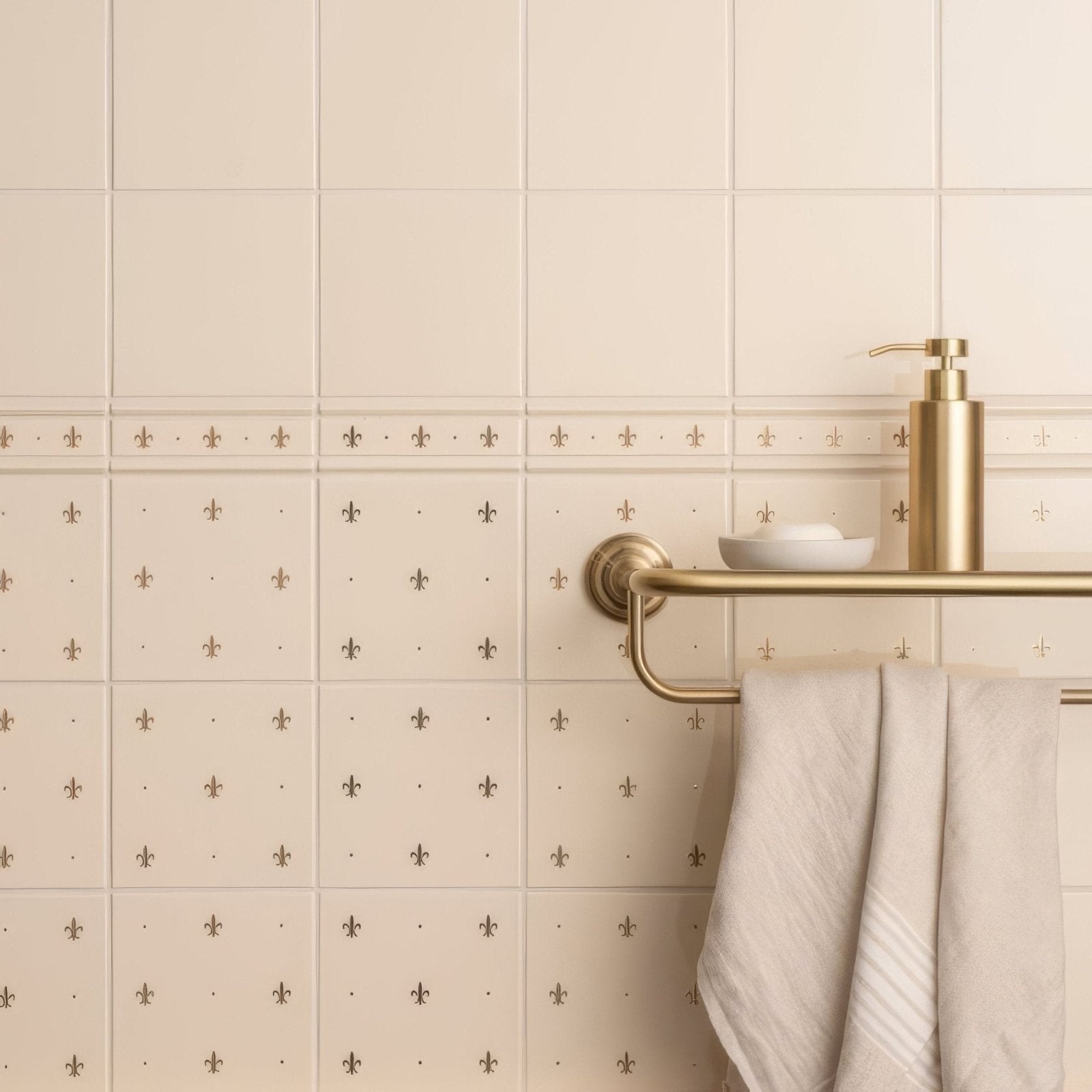 Gold-toned soap dispenser with sleek cylindrical body and polished pump in county white field tile setting