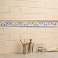 County white omega moulding decorative ceramic tile border with blue and yellow floral motifs on off-white background