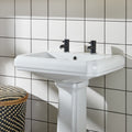 Daisy Satin Field Tile glossy white field tiles with a pedestal sink and black taps