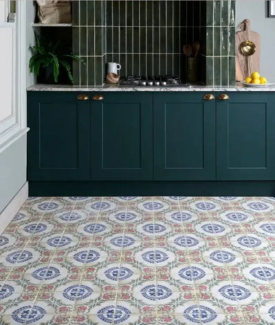 Dark green shaker-style kitchen cabinets with brass handles and a marble countertop.