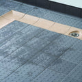 Dark grey multidisc quarry tile 148x148x9mm with gray textured surface raised circular bumps beige border and integrated drain