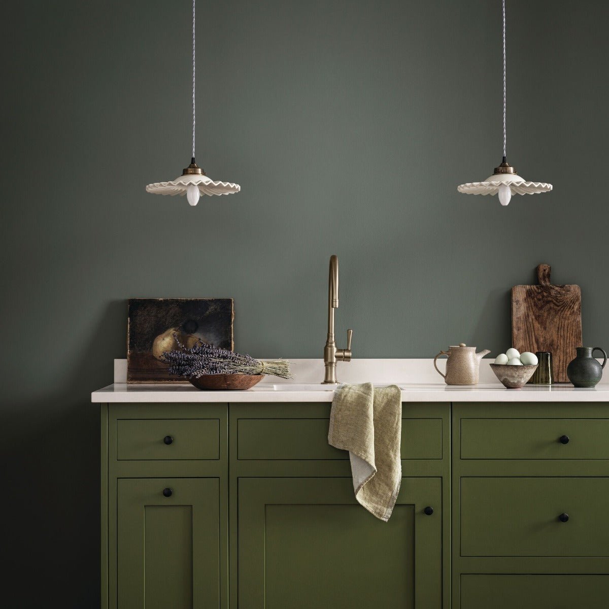 Two white scalloped edge pendant lights with brass fixtures hanging in a room in dartmouth green style