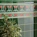 Dauphine border green ceramic tiles with pink and light green art nouveau floral patterns on victorian green background