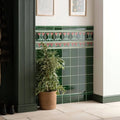 Emerald green ceramic tile wall with a decorative pink and white floral border from dauphine on victorian green