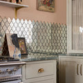 Decorative backsplash of deco glass bell silver mosaic with mirrored quatrefoil tiles framed by dark metal borders