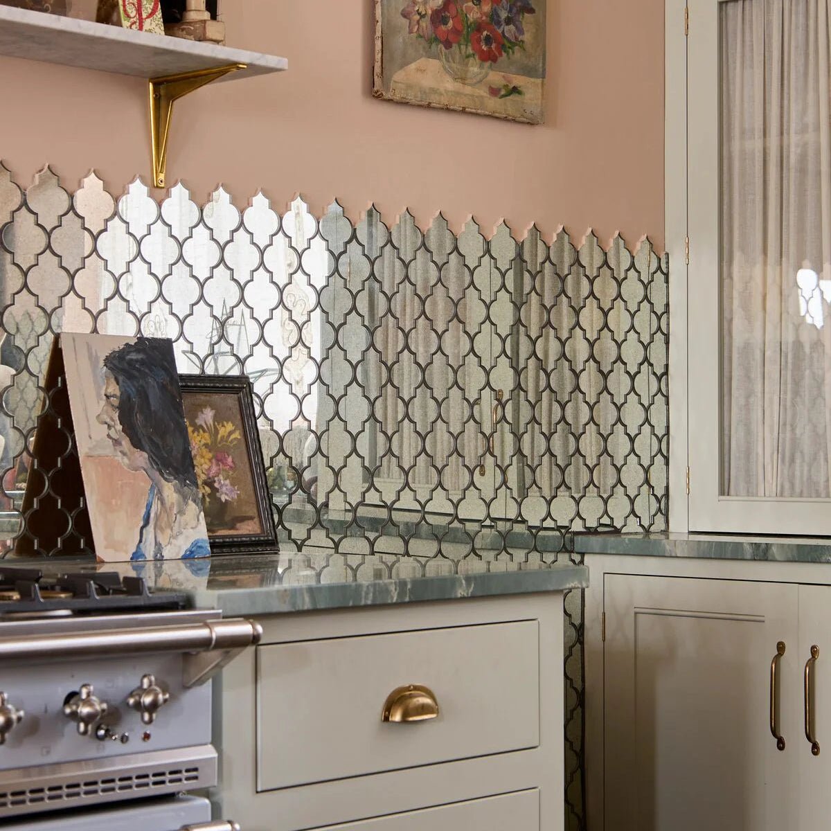 Decorative backsplash of deco glass bell silver mosaic with mirrored quatrefoil tiles framed by dark metal borders