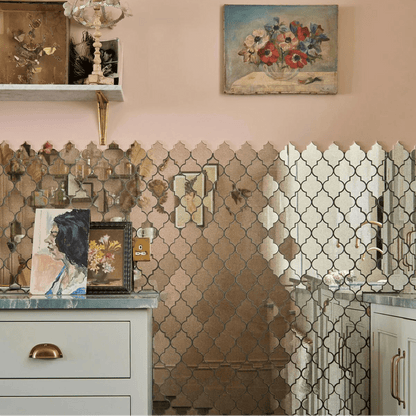 The wall features a deco glass bell silver mosaic with reflective gold and silver quatrefoil mirror tiles