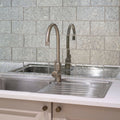 Modern brushed stainless steel kitchen faucet with sleek curved spout and rounded handle for deco glass pewter wall tile setup