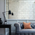 Deco Glass Silver Wall Tile silver mirror wall tile with a grey velvet sofa and orange cushion
