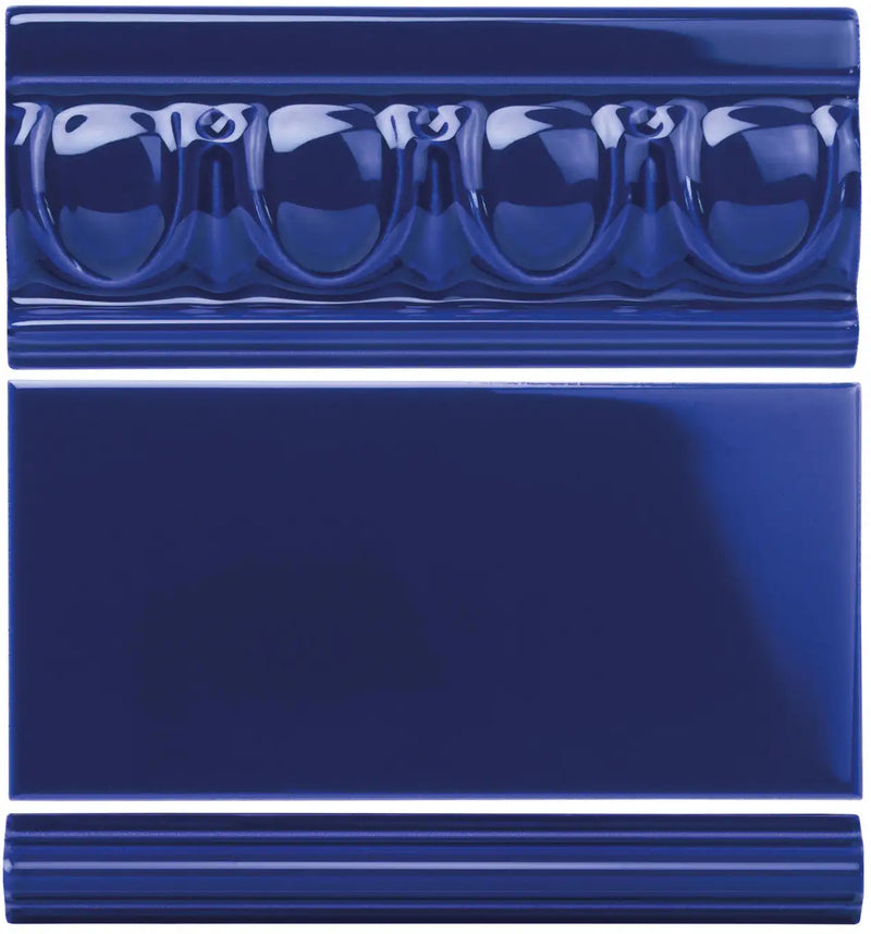 Deep cobalt blue ceramic tile set featuring a decorative molded crown molding piece with rounded arches and two plain rectangular tiles.