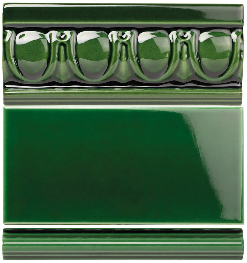 Deep green ceramic tile with a glossy finish and an ornate, raised bead pattern along its top edge.