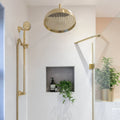 Gold-toned round rain showerhead with textured surface and decorative pattern from delicate wall ceramic metro collection
