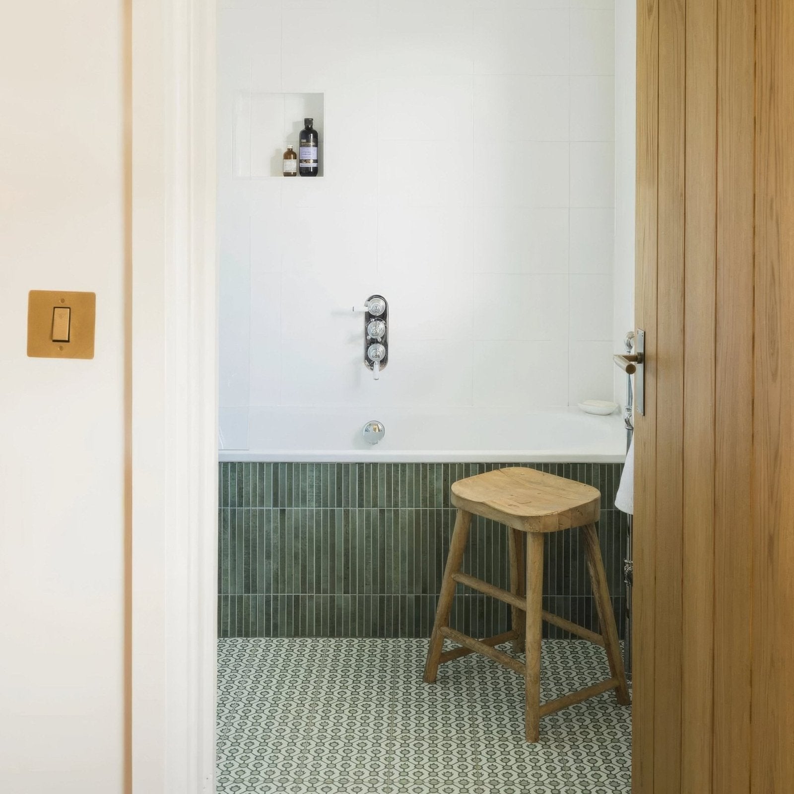 A rustic wooden stool with a square seat and four legs made from light-toned wood by Designers Guild Jaal Moss