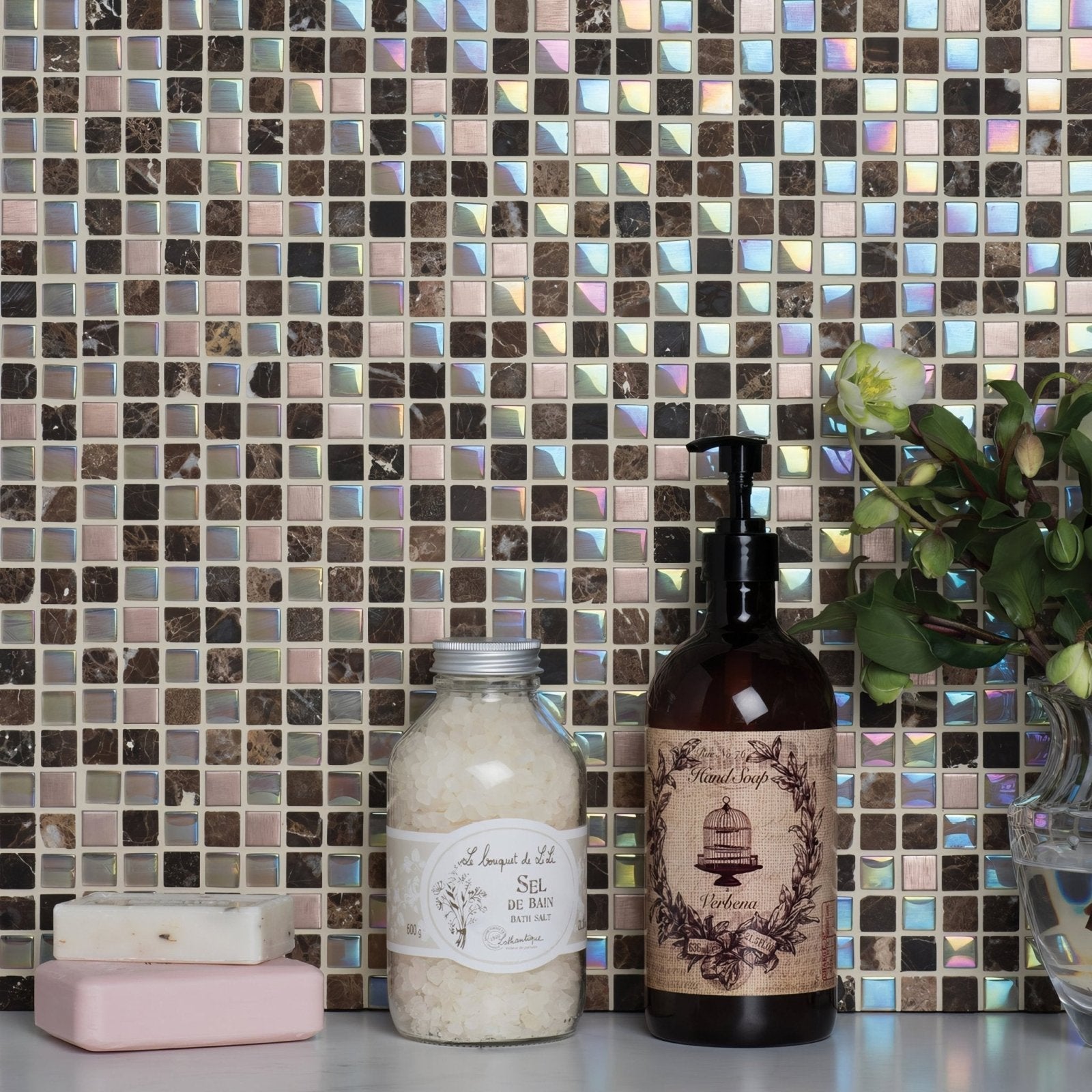 A dark amber glass hand soap bottle with black pump and burlap label featuring a birdcage design by verberne