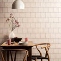 White ceramic vase holding dried pink flowers featured in the field tile dune design collection