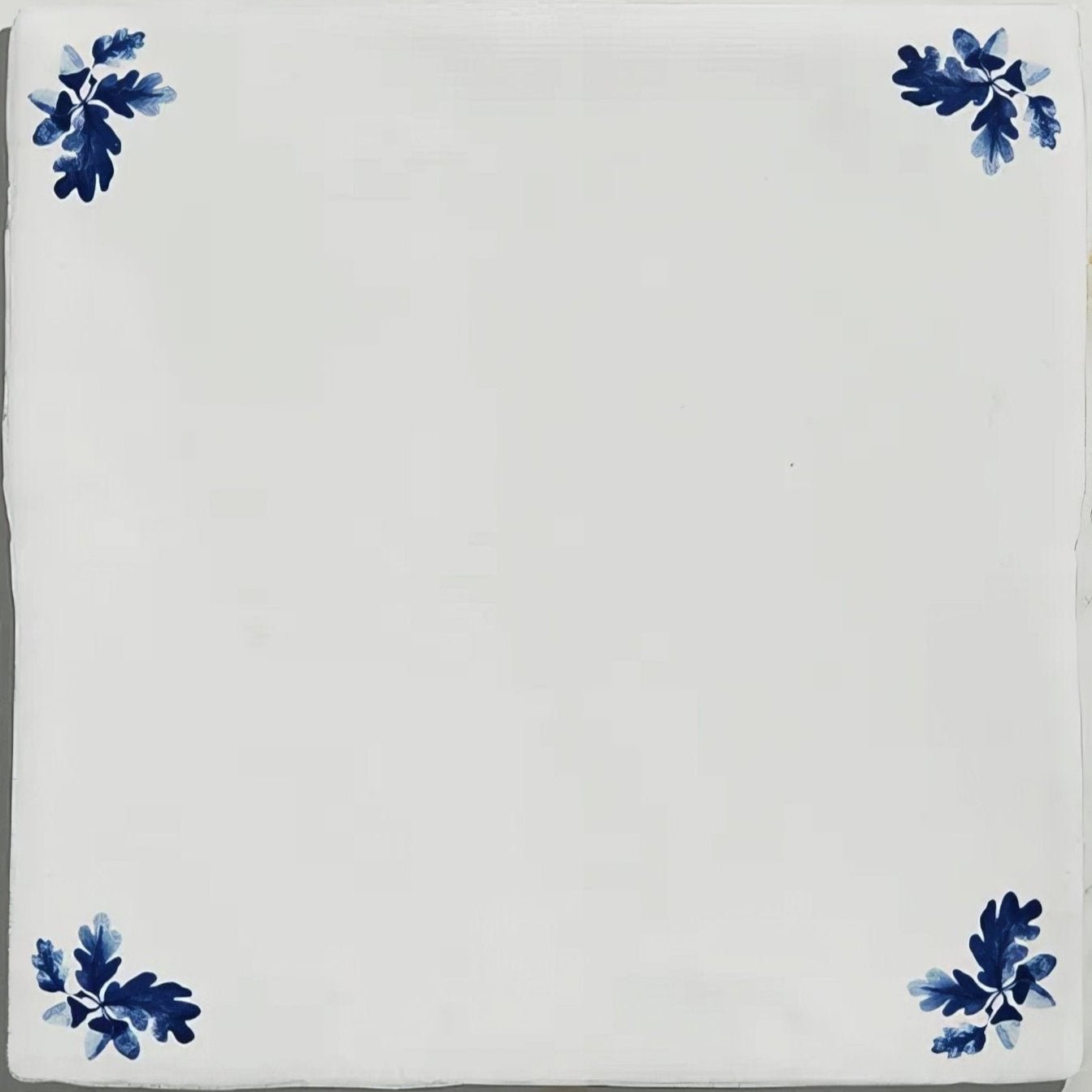 White ceramic tile with blue painted oak leaf motifs in each corner for dyrham dairy ceramic oak leaf corners design